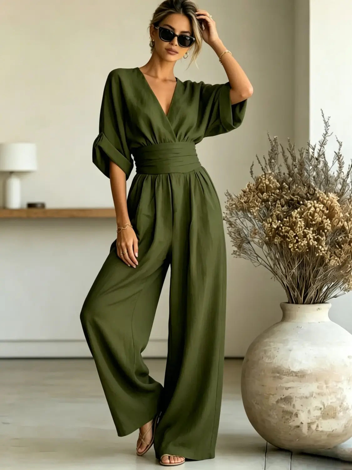 Olive green v-neck wide-leg jumpsuit with a cinched waistband designed for a stylish and comfortable fit.