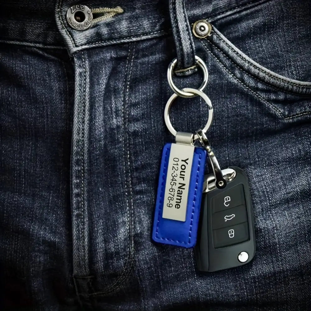 Blue leather customized keychain with engraved silver stainless steel id tag displaying a name and phone number.