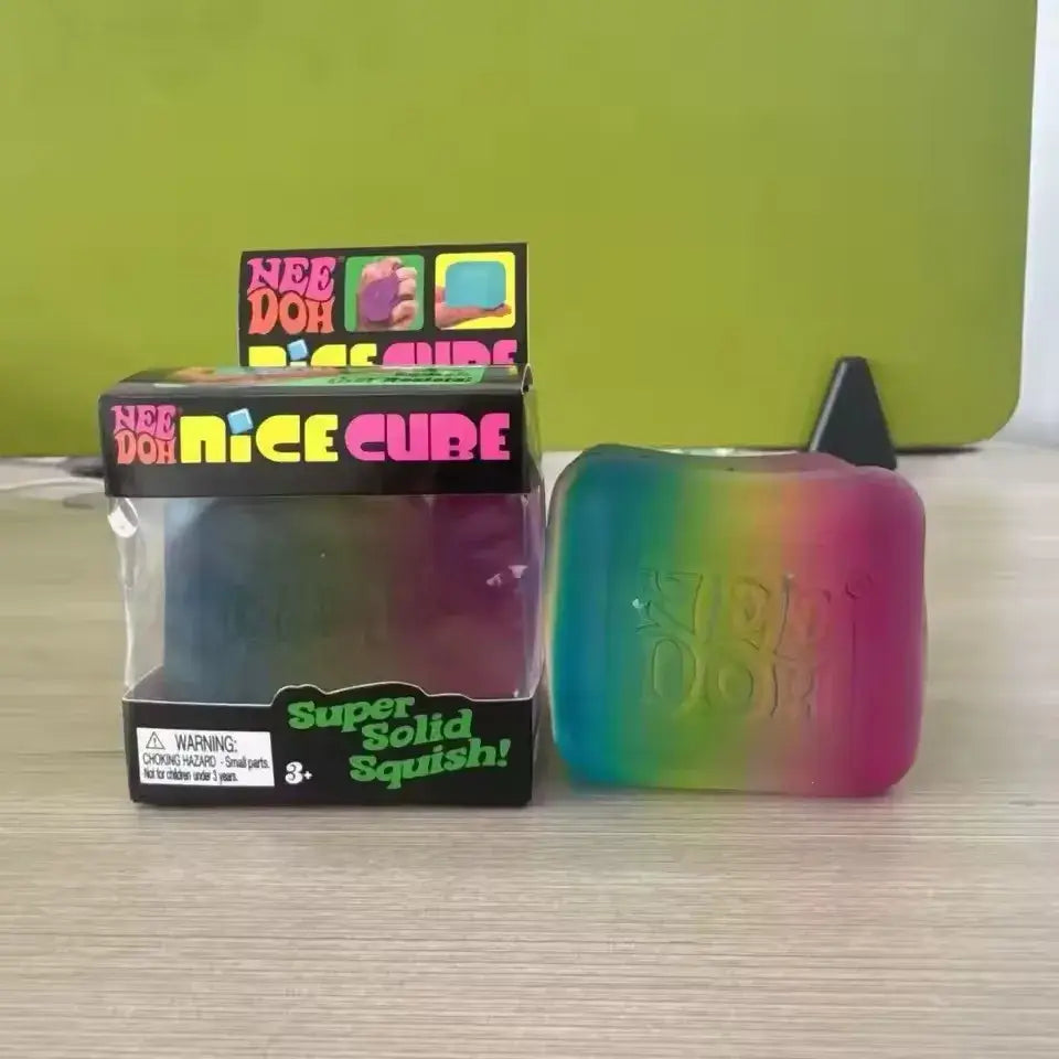 Ein regenbogenfarbenes, transparentes Needoh-Würfel-Fidget-Spielzeug mit einer glatten, nachgiebigen Oberfläche, von einem vorderen Betrachtungswinkel aus gezeigt.