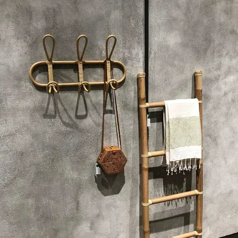 Sechseckige geflochtene Rattan-Handtasche mit braunem Lederriemen, die an einem Bambus-Rattan-Kinder-Wandhaken zur Aufbewahrung von Kleidung hängt.