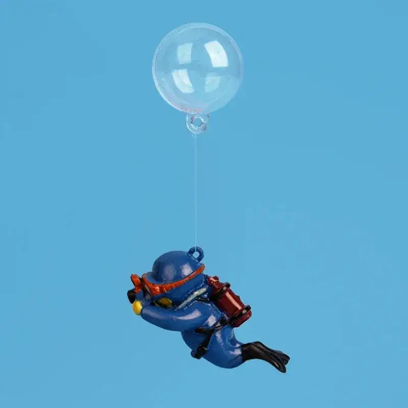 Blue astronaut figurine with red and yellow accents floating beneath a clear balloon popular aquarium decoration for fish tanks landscape decor accessory.