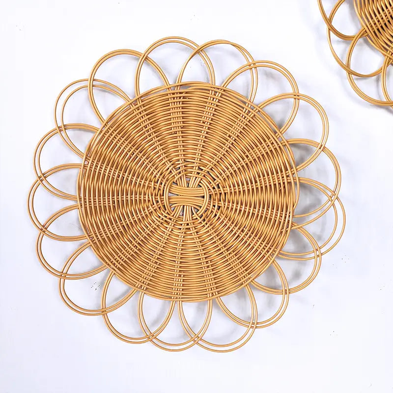 Natural-toned woven rattan placemat featuring a circular flower-like design for woven rattan flower wall hanging decor.