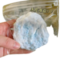 A light blue and white snow skin sea salt squishy toy in a clear bag labeled ice skin sea salt for stress relief