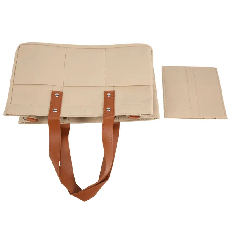 Beige canvas felt baby diaper caddy nursery storage basket with brown leather straps and silver toned metal hardware.