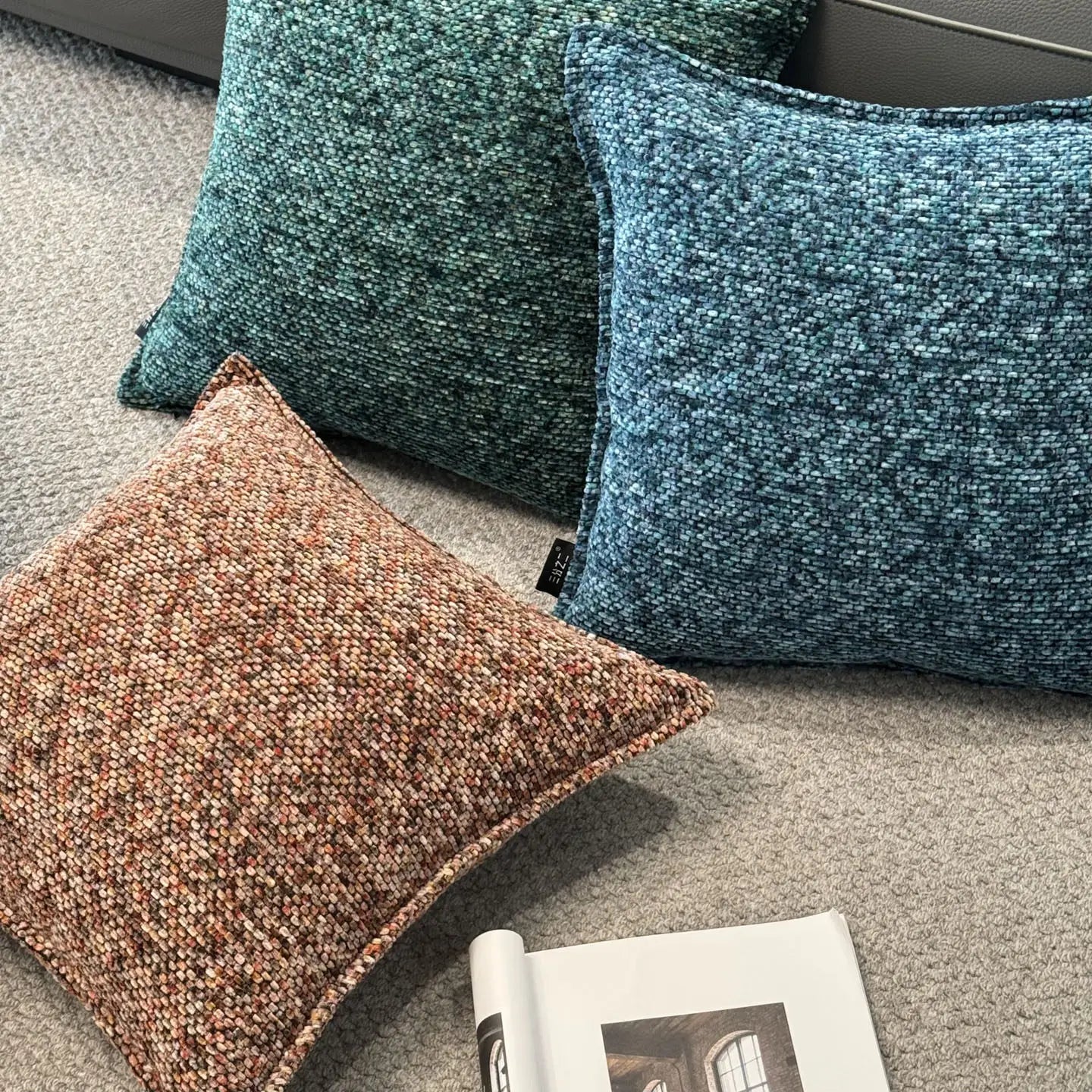 Trois housses de coussin d’appoint en chenille texturées aux tons terreux marron, bleu canard et bleu, avec une finition de tissu tissé pour des coussins décoratifs