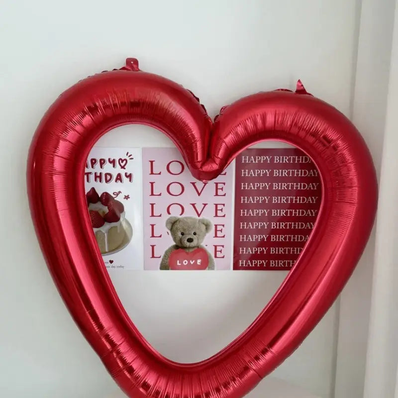 Un globo de lámina para marco de foto de corazón rojo brillante, con acabado metálico brillante y diseños impresos en el interior de su marco, de 40 pulgadas.