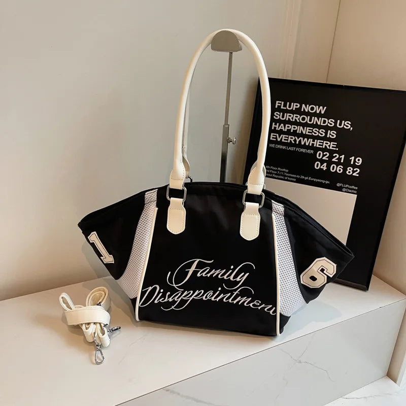 Sac de bowling sportif noir et blanc, tote d’activités sportif brodée avec panneaux latéraux en maille et poignée contrastée de couleur crème, présentant le texte « family disappointment » en script sur l’avant.