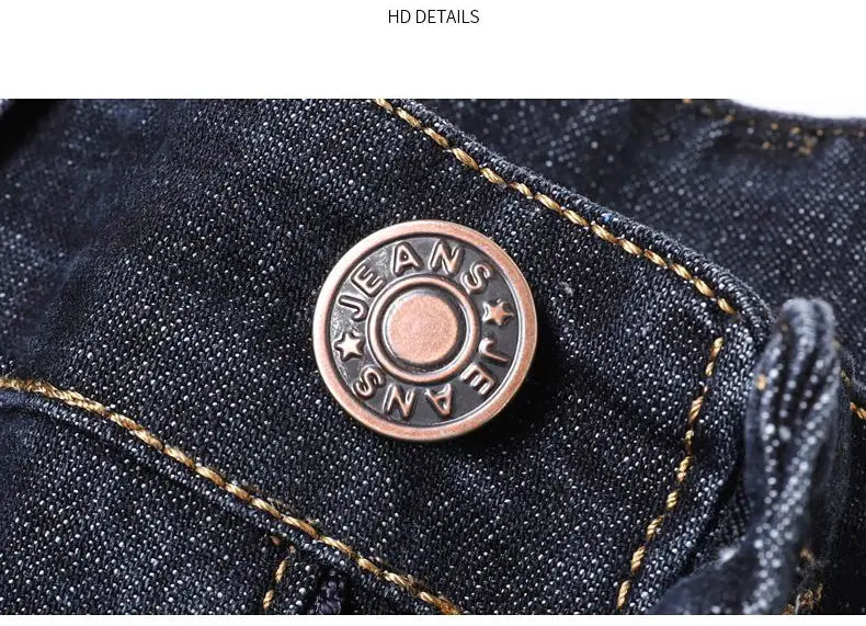 Copper-toned circular denim button engraved with jeans and star motifs on dark blue fabric of men’s stretch cotton straight jeans casual trousers.