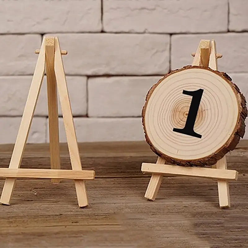 Socle rustique en bois pour numéro de table, réalisé à partir d’une tranche de bois naturel présentant un veinage et un bord d’écorce visibles, affichant le chiffre noir 1, convenant pour la décoration d’engagement de mariage et la décoration de mariage d’anniversaire.
