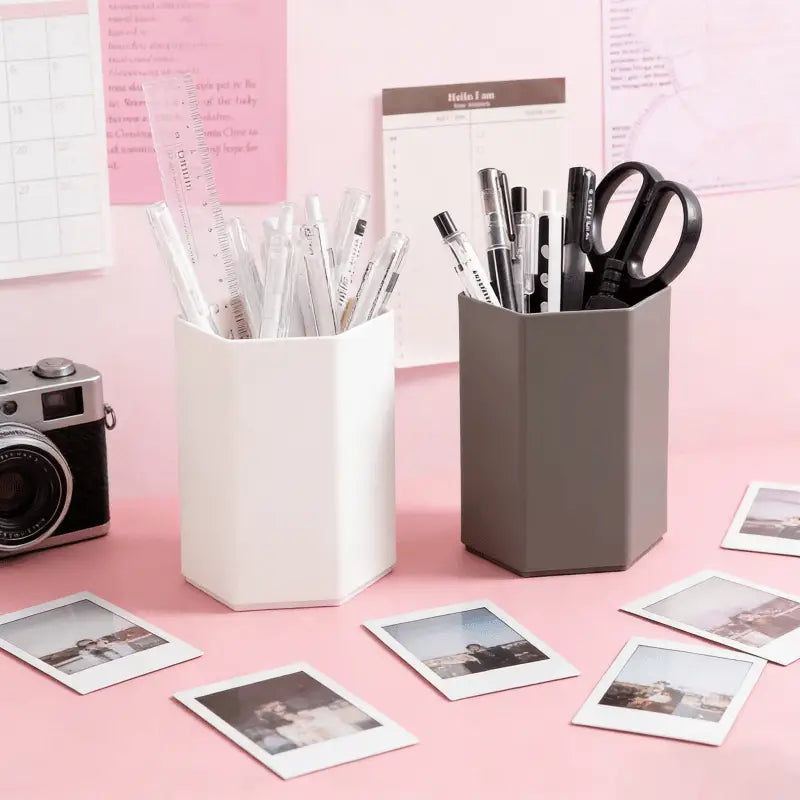 White hexagonal plastic pen holder desk organizer filled with pens and a ruler for office or study use.