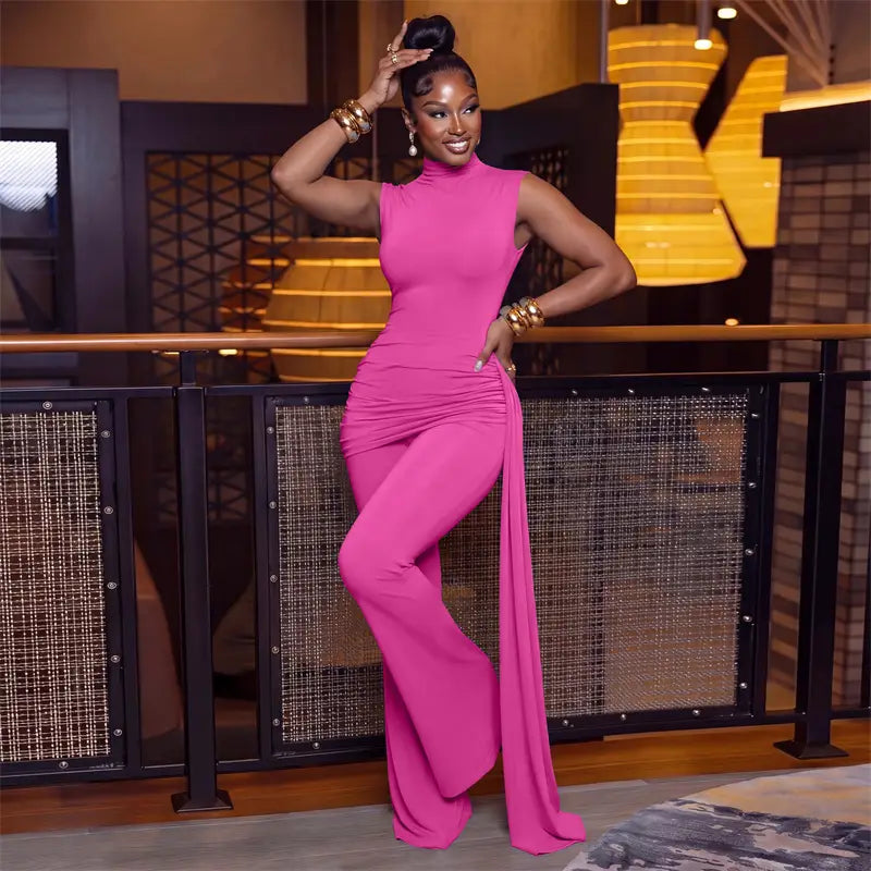 A vibrant fuchsia sleeveless high-neck jumpsuit with ruched side slit and wide-leg pants featuring a zip closure type from the piece sets woman collection.
