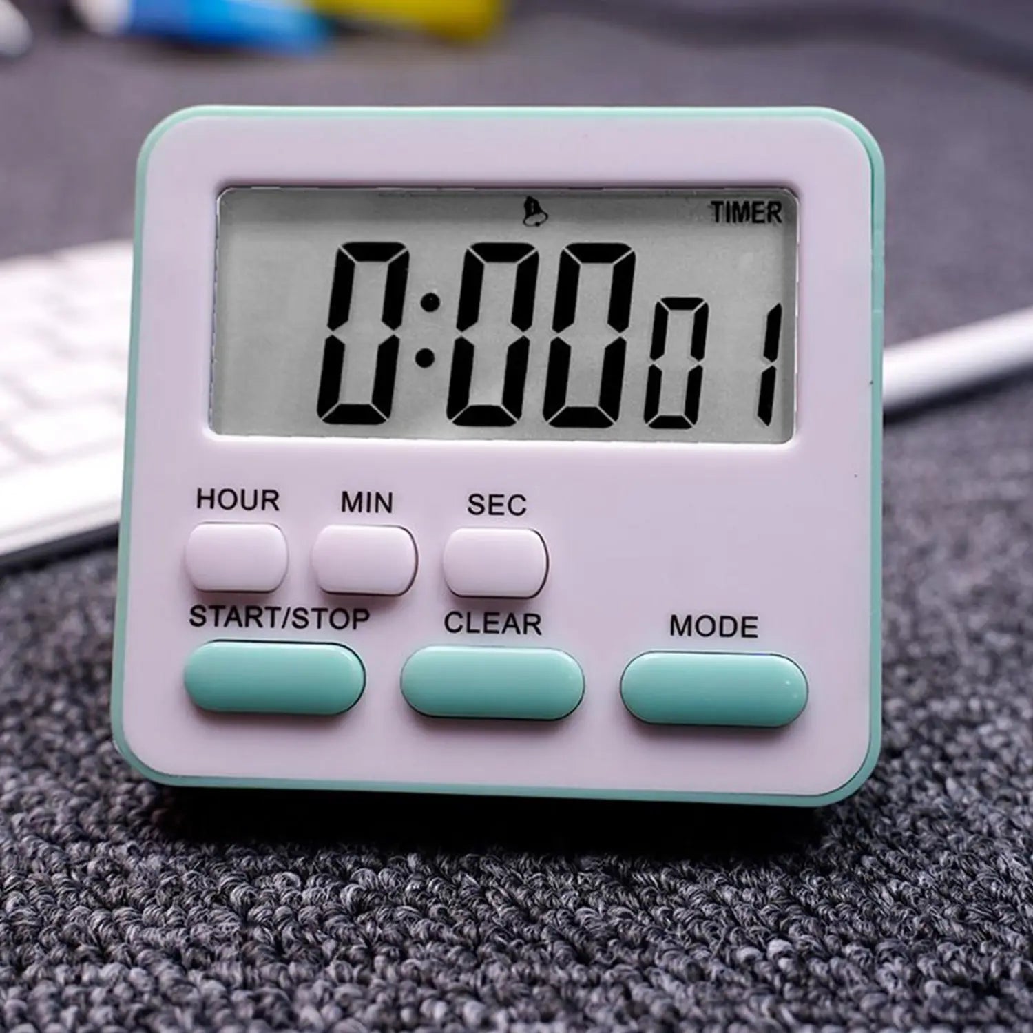 Ein kompakter digitaler Küchentimer als geräuschlose Countdown-Uhr mit weißem und mintgrünem Kunststoffgehäuse, mit schwarzem LED-Display und beschrifteten Tasten für Stunde, Minute, Sekunde, Start, Stopp, Löschen und Modus.