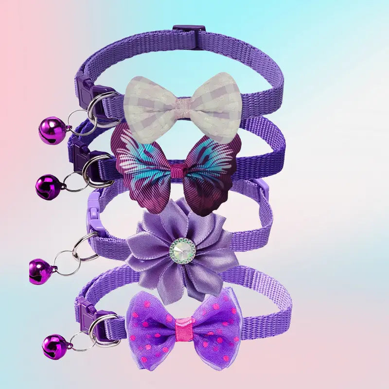 adjustable purple woven bow cat collars with decorative flower centerpieces and small metallic bells.