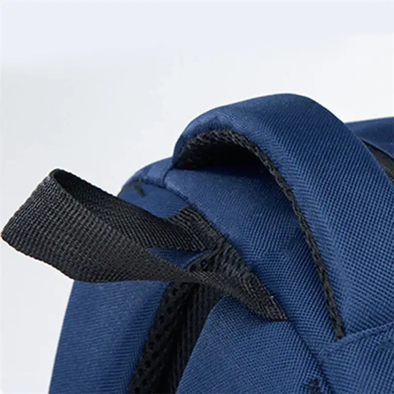 Blauer Nylon-Rucksackgurt mit schwarzem Webband und Naht auf der Rückseite eines Jungen-Wasserschulrucksacks in Navyblau mit blauem Buchfach-Tasche