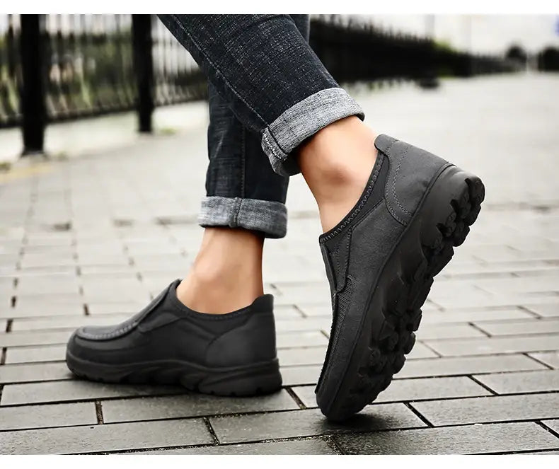 Mocassins homme décontractés en cuir à enfiler en noir, avec des détails cousus et une semelle en caoutchouc texturée conçue pour le confort et le style.