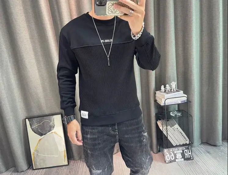 Pull-over en maille à empiècement contrastant pour homme, manches longues, noir en maille côtelée, avec un empiècement texturé contrastant sur la poitrine et des lettrages blancs sur le côté gauche.