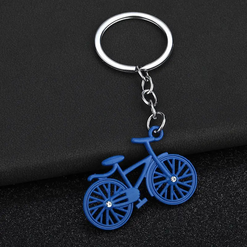 Blue bicycle-shaped keychain charm set featuring a silver metal ring and chain for convenient attachment.