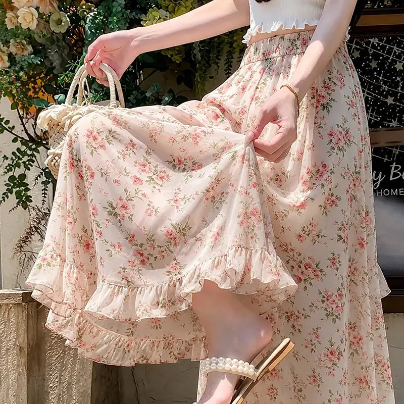 Ein fließender Maxirock in Hellrosa mit floralen Motiven, zartem Volantabschluss und elastischem Bund, entworfen als Sommerhose mit weitem Bein für Damen