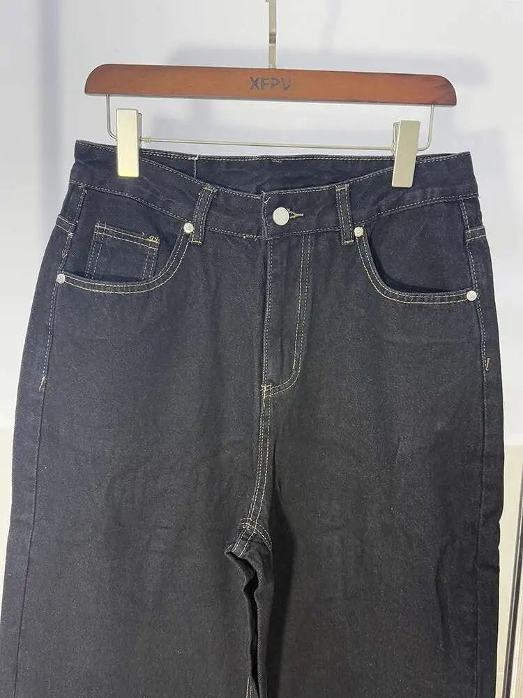 Iefb men black vintage wide leg jeans made of dark-wash denim with white stitching and silver-toned buttons hanging on a wooden hanger.