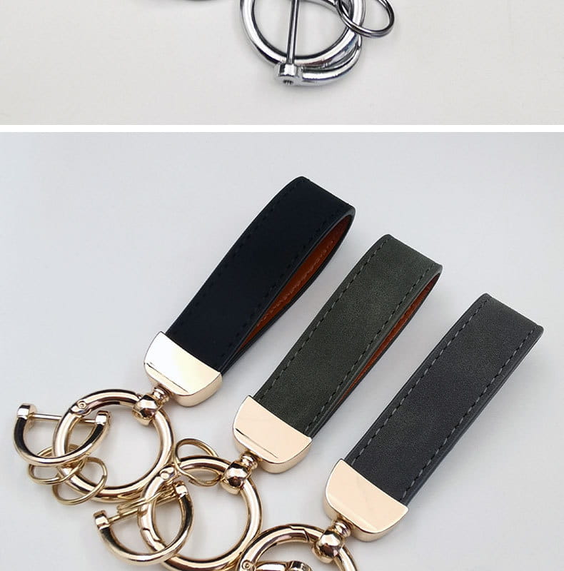 Three genuine leather keychains with gold-tone metal rings and caps featuring black dark green and charcoal gray straps for car key rings.