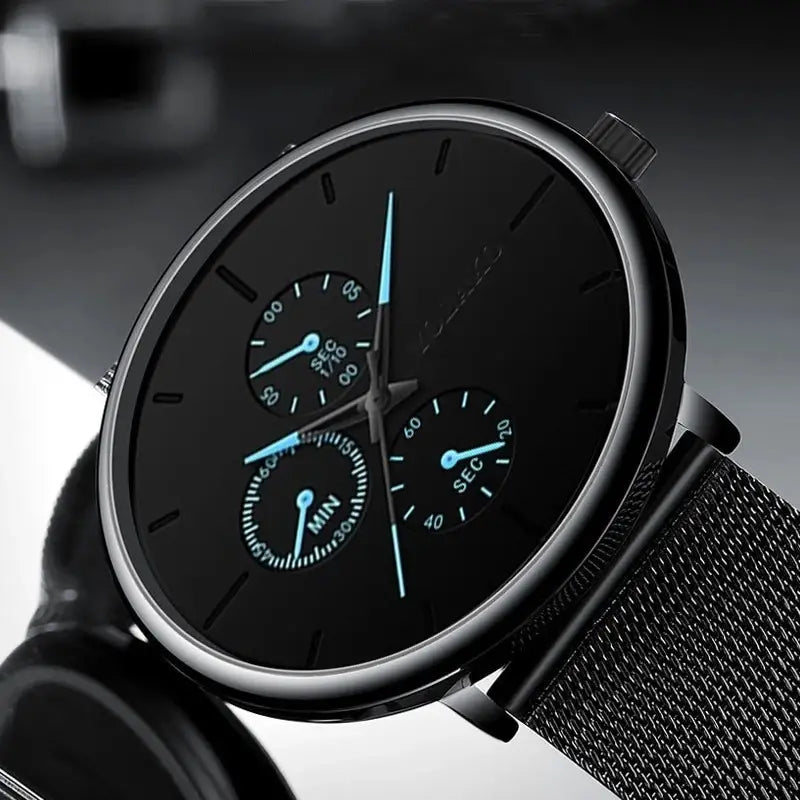 Montre à quartz à maille noire ultrafine pour hommes, avec un bracelet en maille d’acier inoxydable noir, un cadran noir épuré et des aiguilles bleu lumineux.