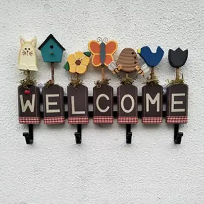 brown wooden welcome wall sign with painted animal and nature-themed cutouts above each letter and black hooks for hanging items displayed alongside pomni clown costume dress size chart