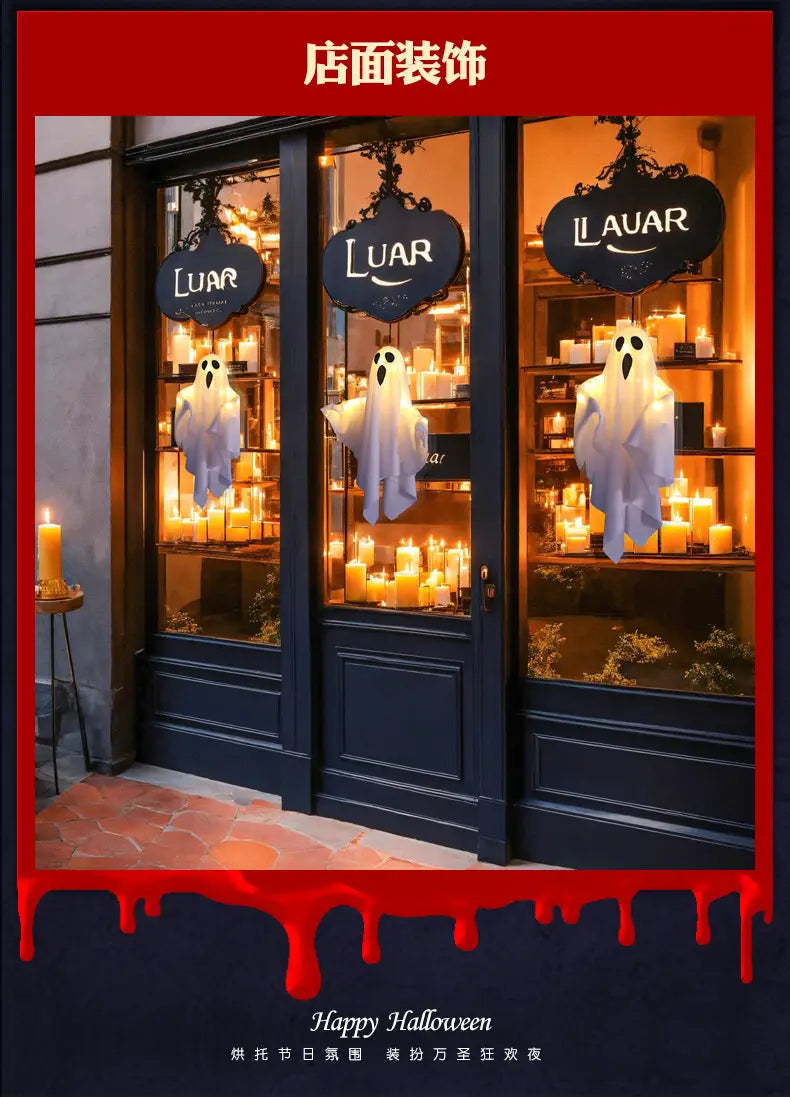 Décoration d’Halloween fantôme blanche lumineuse suspendue devant des vitrines de magasin aux teintes bleu foncé, affichant des bougies et des enseignes de marque