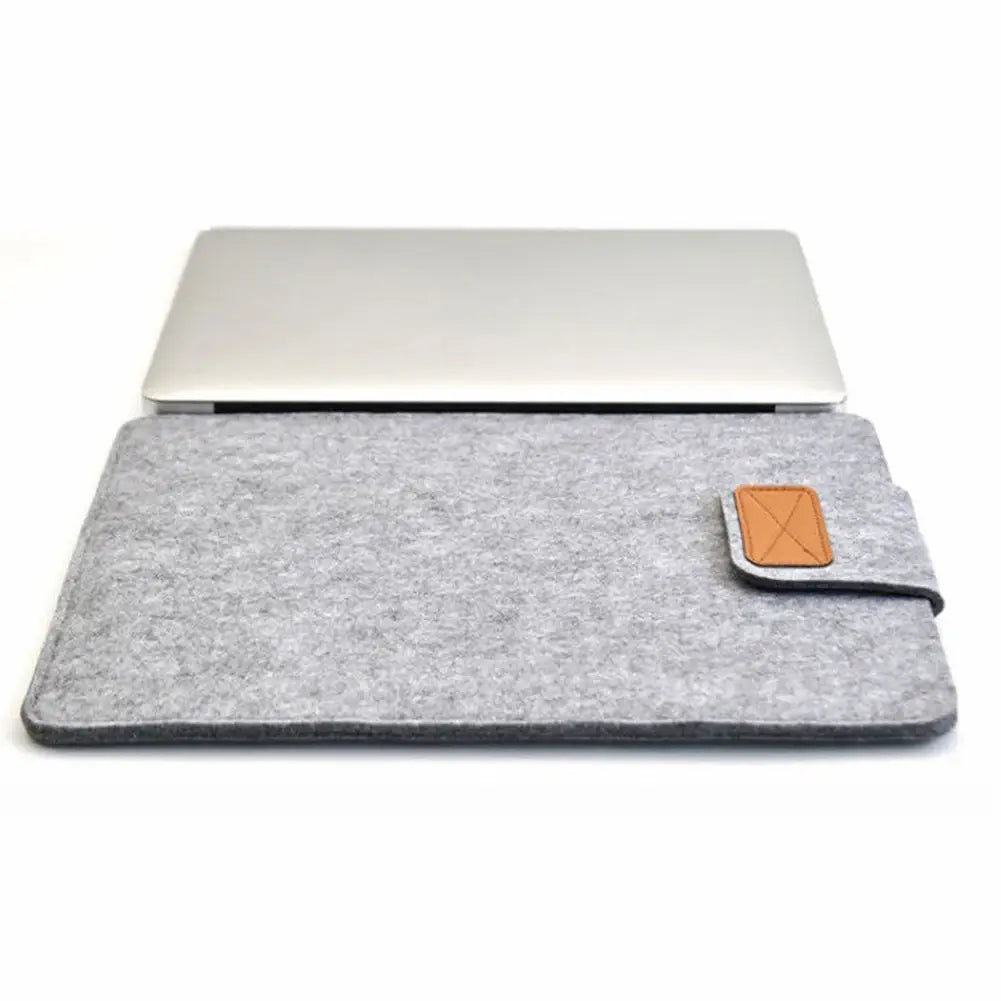 gray felt laptop bag sleeve for macbook air with tan leather flap and stitched edges designed to protect and carry a silver laptop or tablet bag
