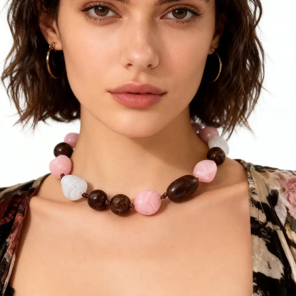 Collier ras du cou en résine à motif géométrique, fait de perles marbrées, au style affirmé, avec des perles lisses et arrondies dans des tons rose pâle, brun profond et blanc crème.