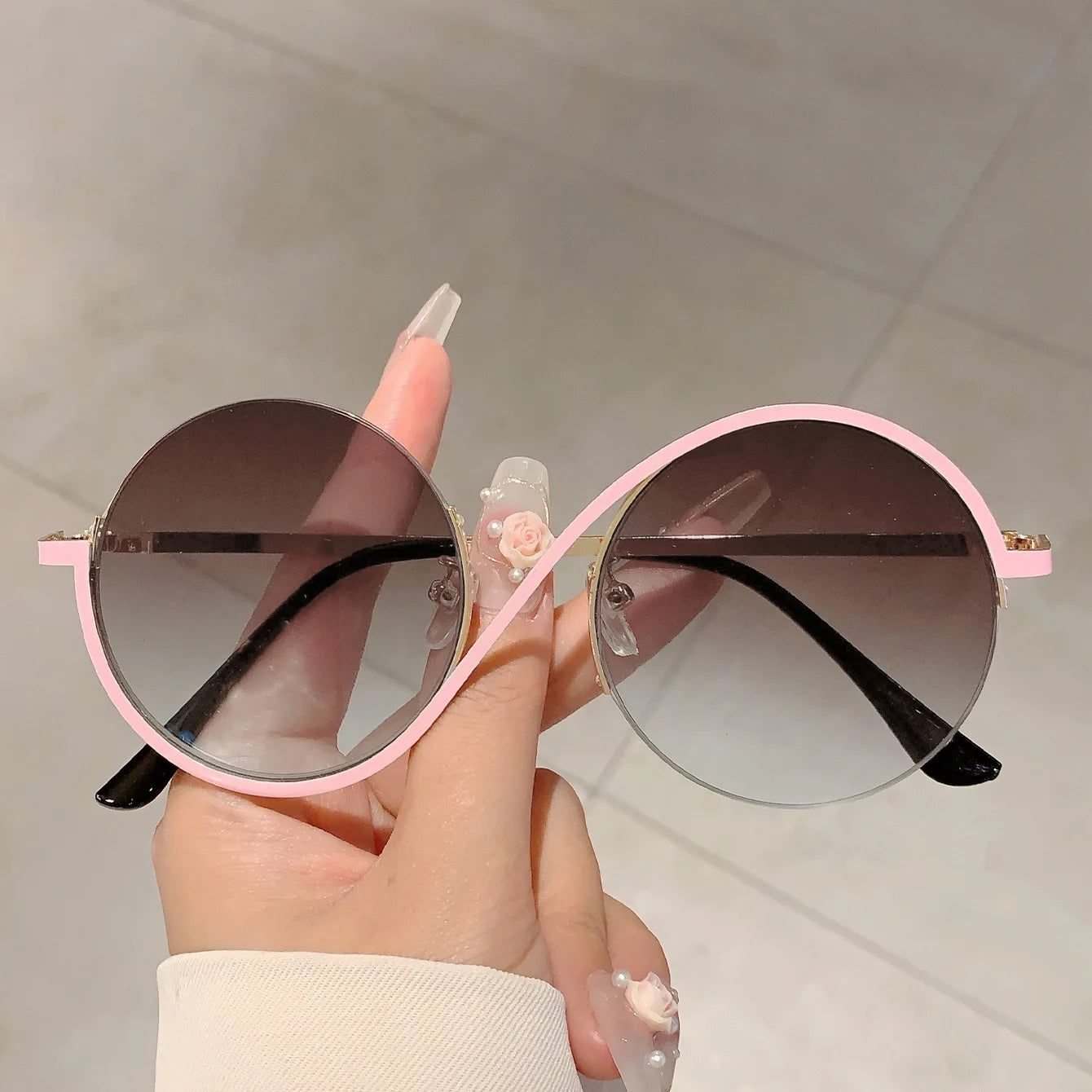 Gafas de sol con montura redonda rosa, lentes marrones con degradado y detalles con acabado dorado, ideales para atuendos de moda y diversas situaciones aplicables