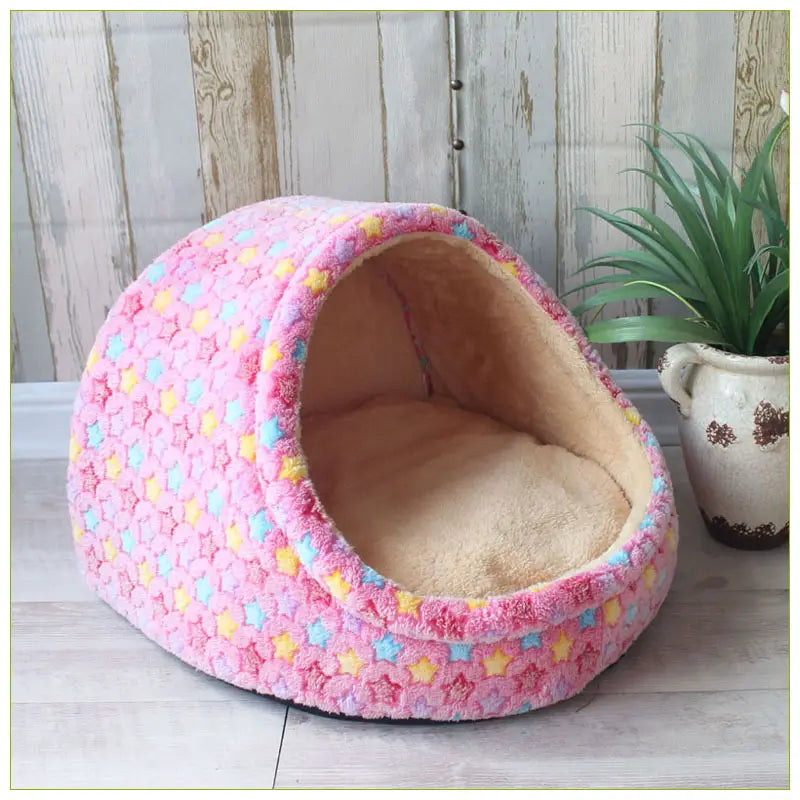 foldable plush pet cave bed for small dogs and cats in pink with star patterns and a soft beige interior.