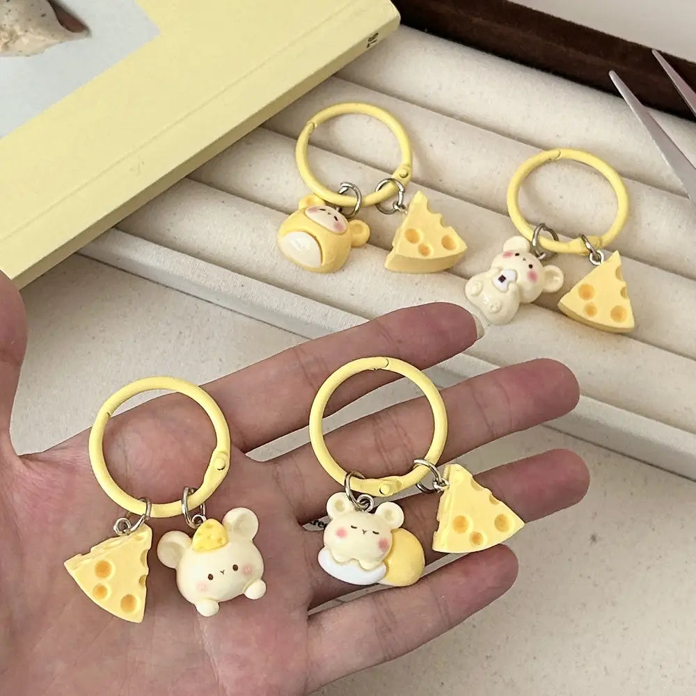 Yellow plastic keychain featuring a cute white mouse figurine and a slice of cheese charm as a kawaii bag charm.