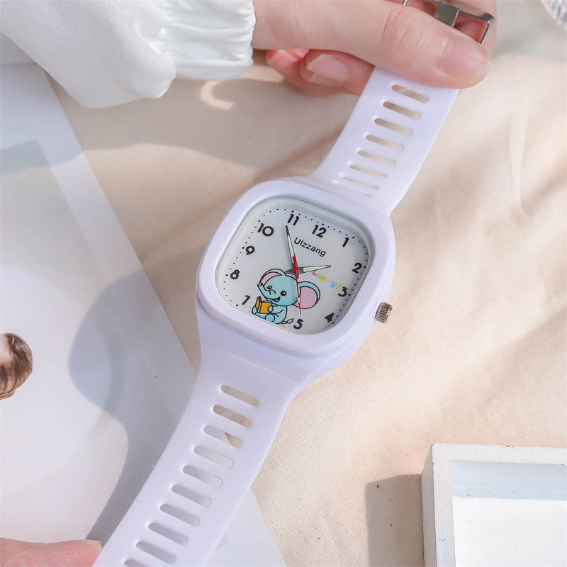 White square-faced kids digital watch with a cartoon elephant design on the dial and a perforated silicone strap featuring luminous display.