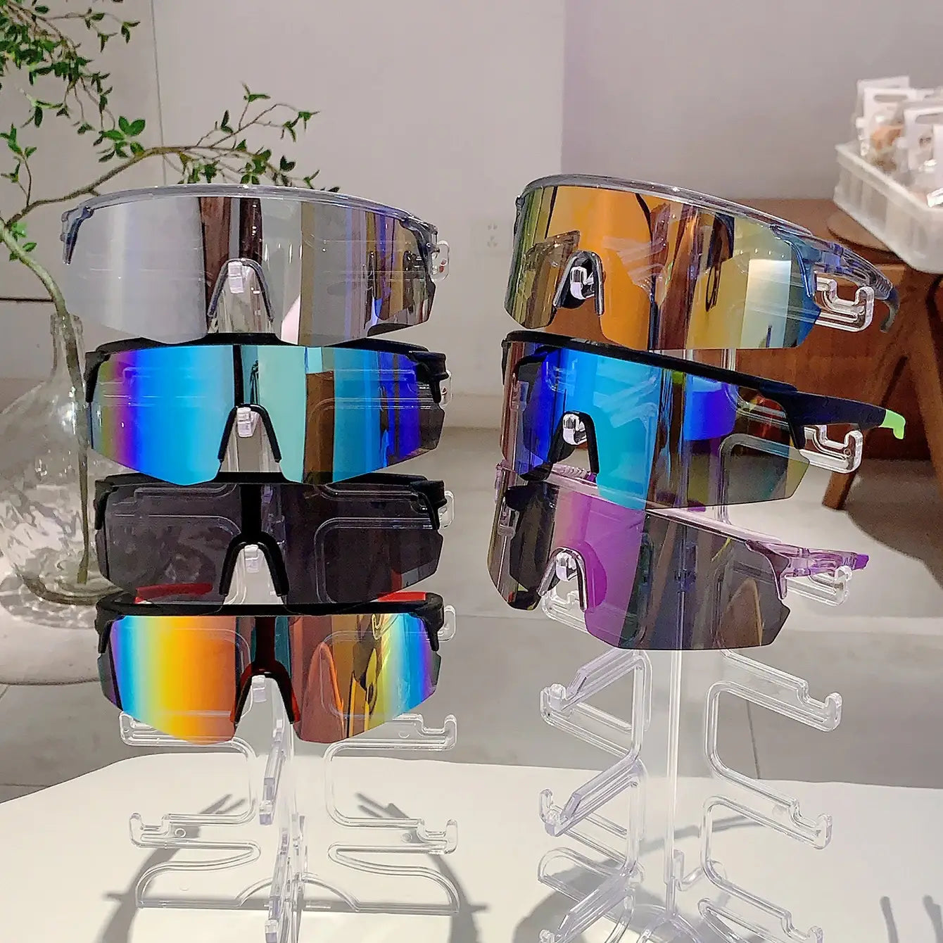 Paires empilées de lunettes de soleil de sport surdimensionnées, avec des montures noires élégantes et des verres dégradés irisés réfléchissants, conçues pour le cyclisme et les sports en plein air.