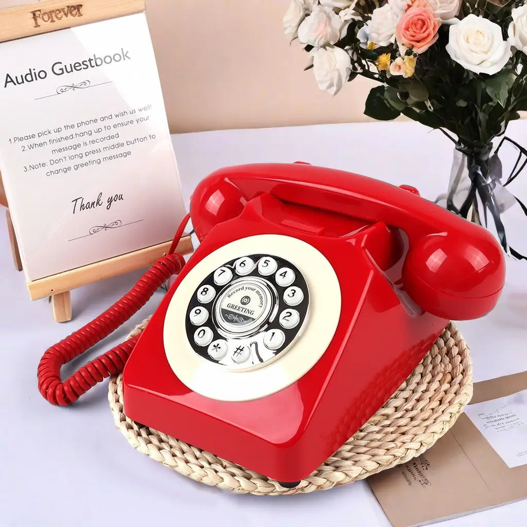 Teléfono de registro de audio antiguo para bodas y eventos con un auricular rotatorio rojo vibrante con un dial color crema y acabado de plástico brillante.