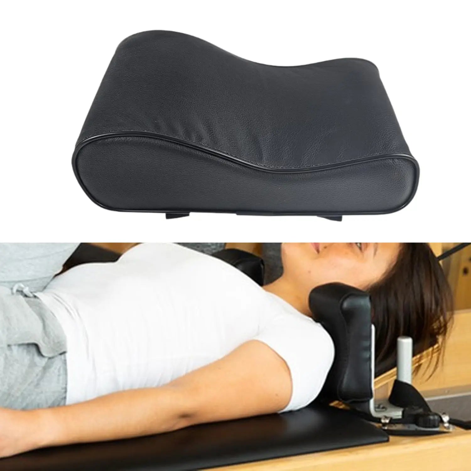 Black ergonomic neck support pillow with contoured cushioned design and stitched edges for Pilates reformer use.