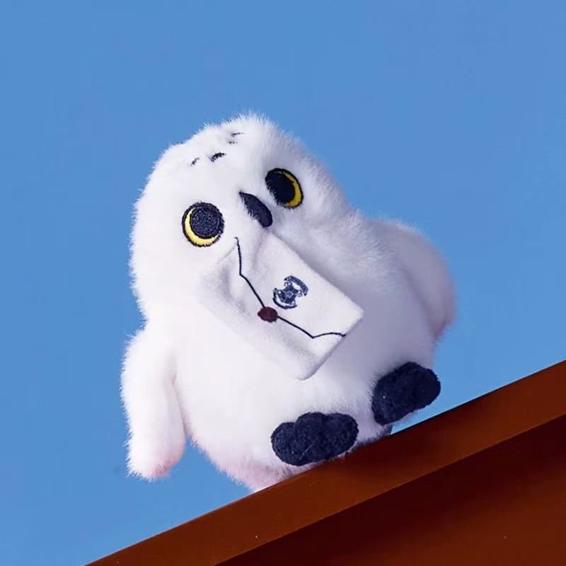 fluffy white owl plush toy keychain featuring a soft snowy owl with yellow eyes black feet and holding a small embroidered envelope