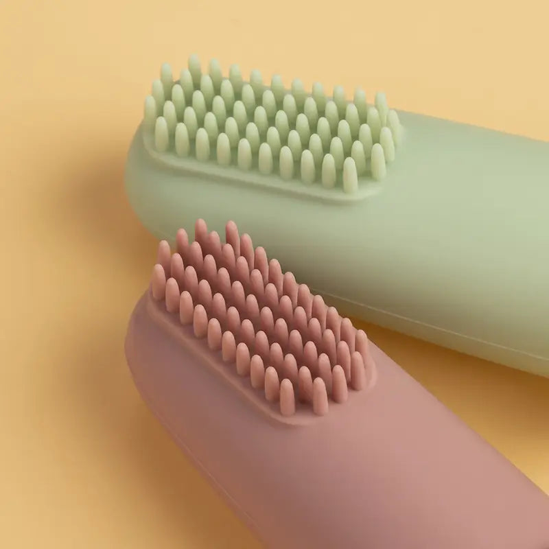 Pastellrosa- und Minzgrüne Silikon-Babysfingernzahnbürsten mit weichen, abgerundeten Borsten, BPA-frei.