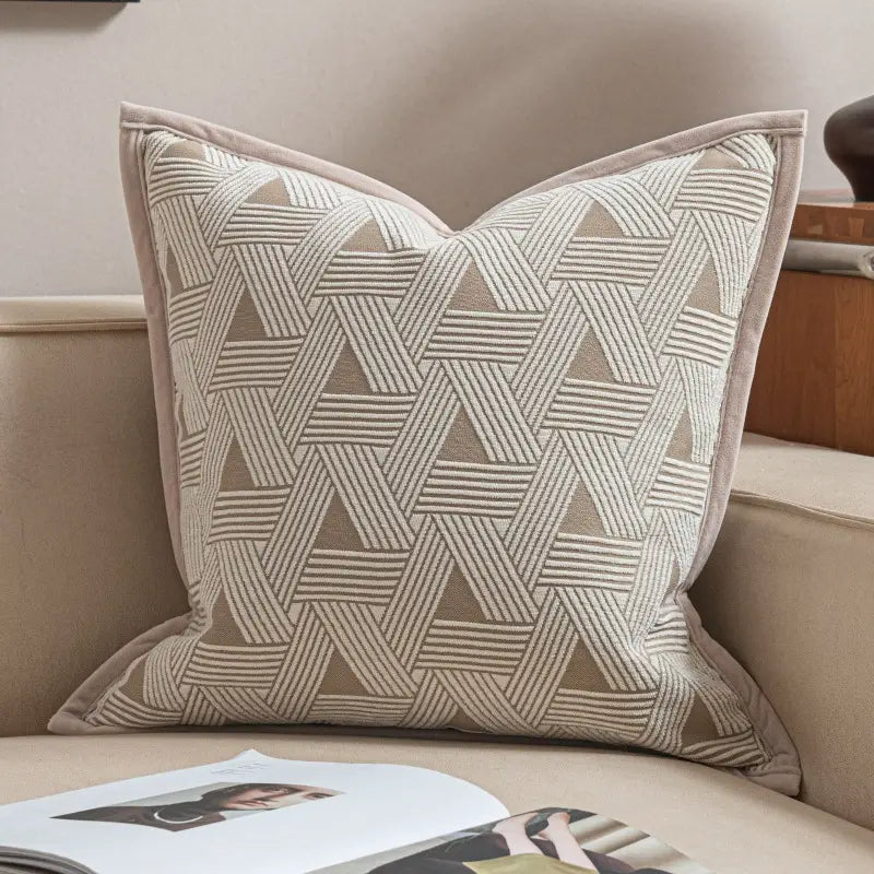 housse de coussin de luxe beige couleur lin sec présentant un motif tissé géométrique aux tons crème et taupe, avec une bordure de tissu assortie