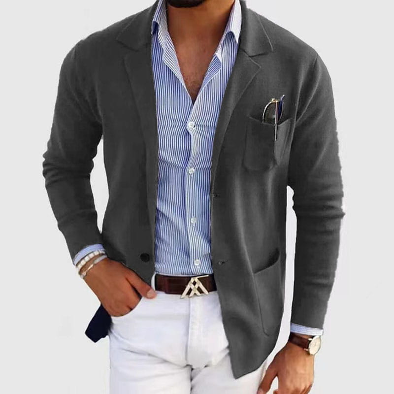 Chaqueta tipo blazer gris oscuro, de ajuste entallado, con tejido texturizado y brillo sutil, con solapas tipo púa y diseño de chaqueta de traje de una sola fila de botones.