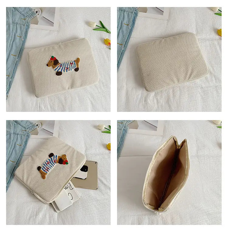 Beige Kord-Laptophülle für MacBook Pro mit einem bestickten Dackel in einem gestreiften Pullover und roter Mütze.