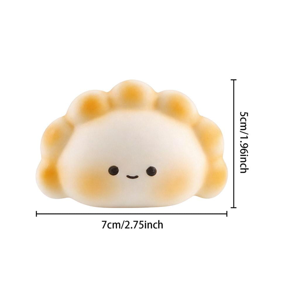 Juguete squishy para aliviar el estrés en color blanco y marrón dorado, con forma de dimsum y carita sonriente, diseñado como un juguete para aliviar el estrés para juguetear y relajarse.
