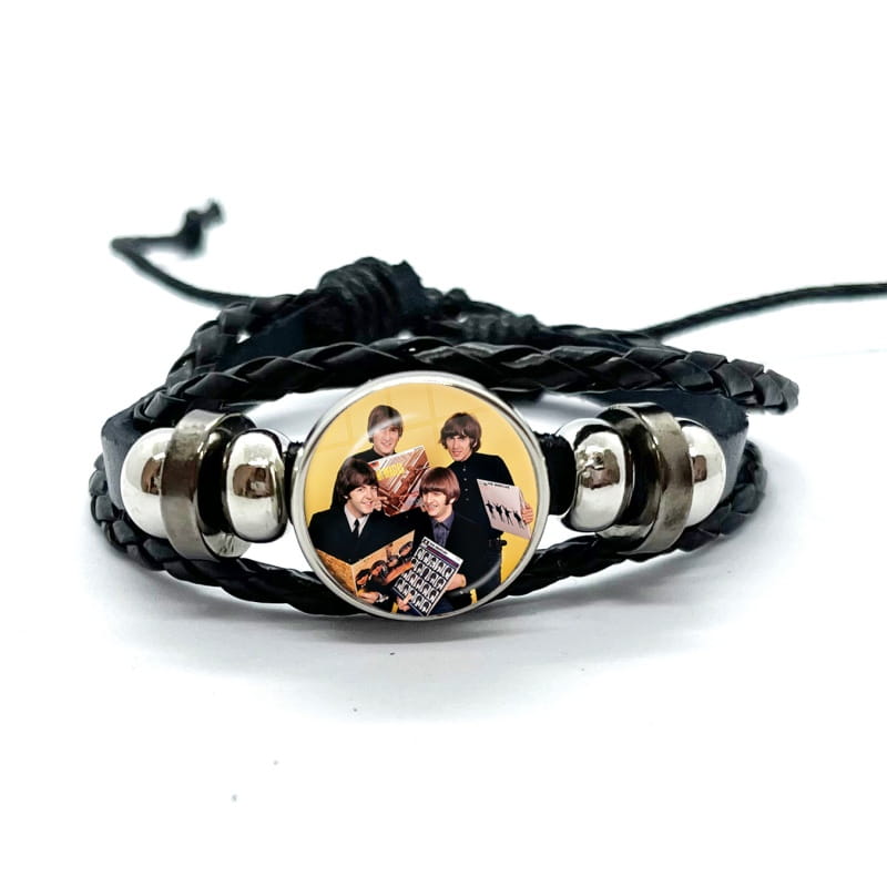 black braided leather bracelet with silver-toned metal beads and a circular glass dome charm featuring the beatles logo.