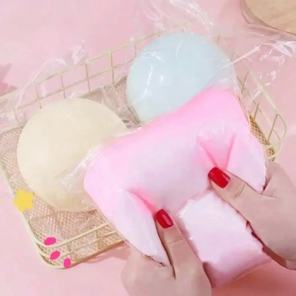 Una pelota blanda y esponjosa rosa con acabado mate, sostenida en las manos para aliviar el estrés y la ansiedad.