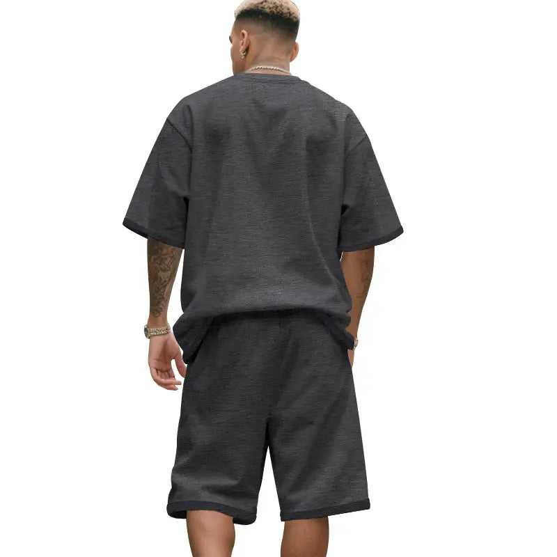 Camiseta oversize de algodón gris oscuro de manga corta con ajuste relajado y tela con textura sutil, del conjunto veraniego casual para hombre de dos piezas, camiseta y pantalones cortos.