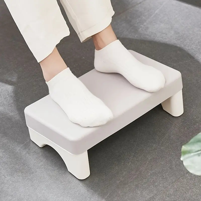 Repose-pieds de bureau ergonomique minimaliste en plastique blanc, bords arrondis et pieds robustes légèrement incurvés, conçu pour une utilisation sous le bureau