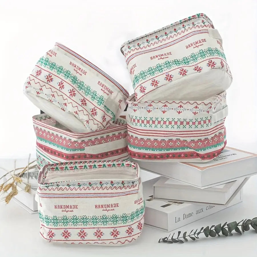 Panier de rangement pliable en tissu blanc avec des motifs brodés rouge et vert, et un texte fait main présentant une texture tissée, pour un usage comme panier de rangement ou boîte de rangement