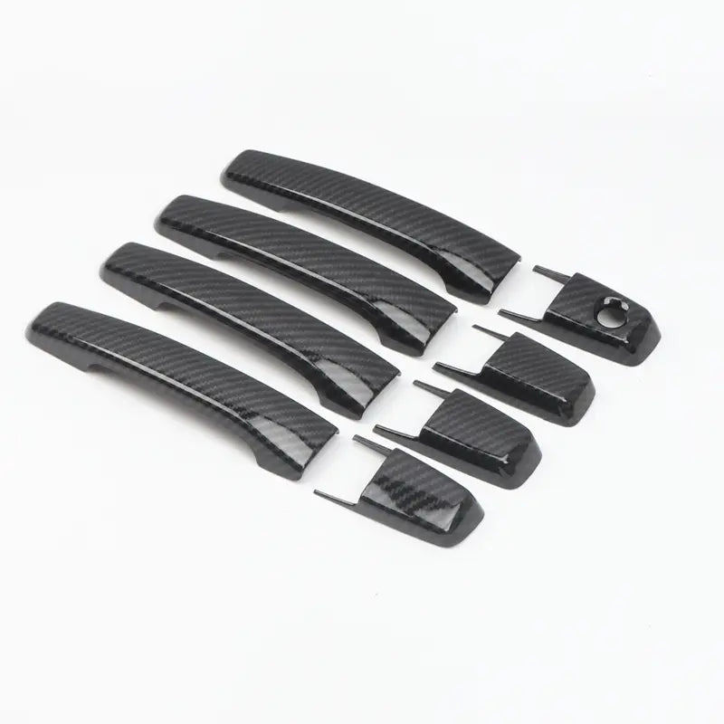 Lot de caches de poignées de porte à texture en fibre de carbone noire avec embouts de finition assortis pour la garniture de poignée de porte en chrome Mitsubishi Pajero 2007 à 2021.
