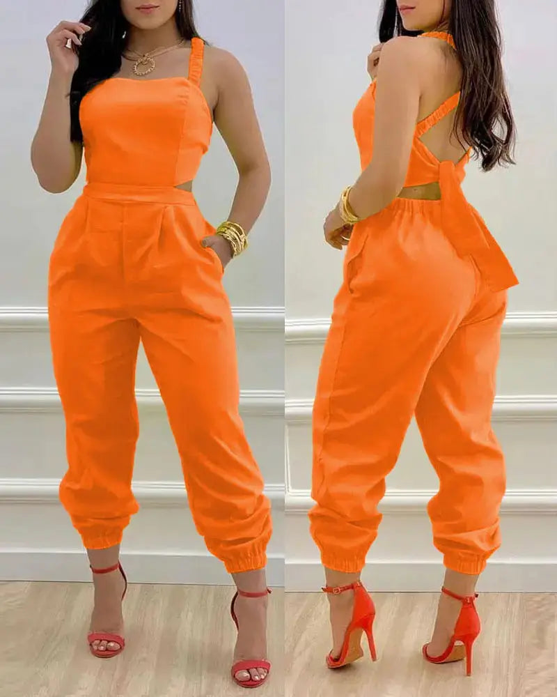 Bright orange women summer printed cutout jumpsuit with halter neckline side cutouts and elastic cuffs.
