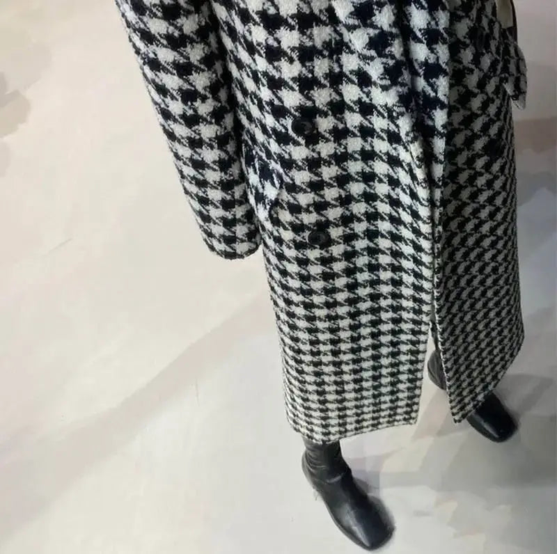 A black and white houndstooth wool coat featuring a classic double breasted design.